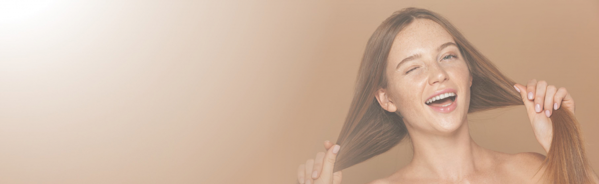 mujer que tira de su pelo largo después de realizarse un tratamiento para la caida del cabello